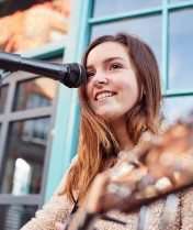 female-musician-busking-playing-acoustic-guitar-QGPZ2UP.jpg