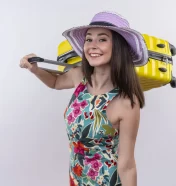 smiling-young-traveler-woman-holding-suitcase-on-isolated-white-wall